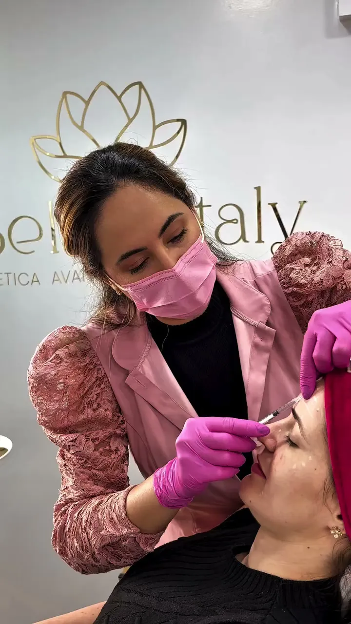 Karla Daniele, de máscara e luvas, aplicando toxina botulínica numa paciente, na Belle Vitaly